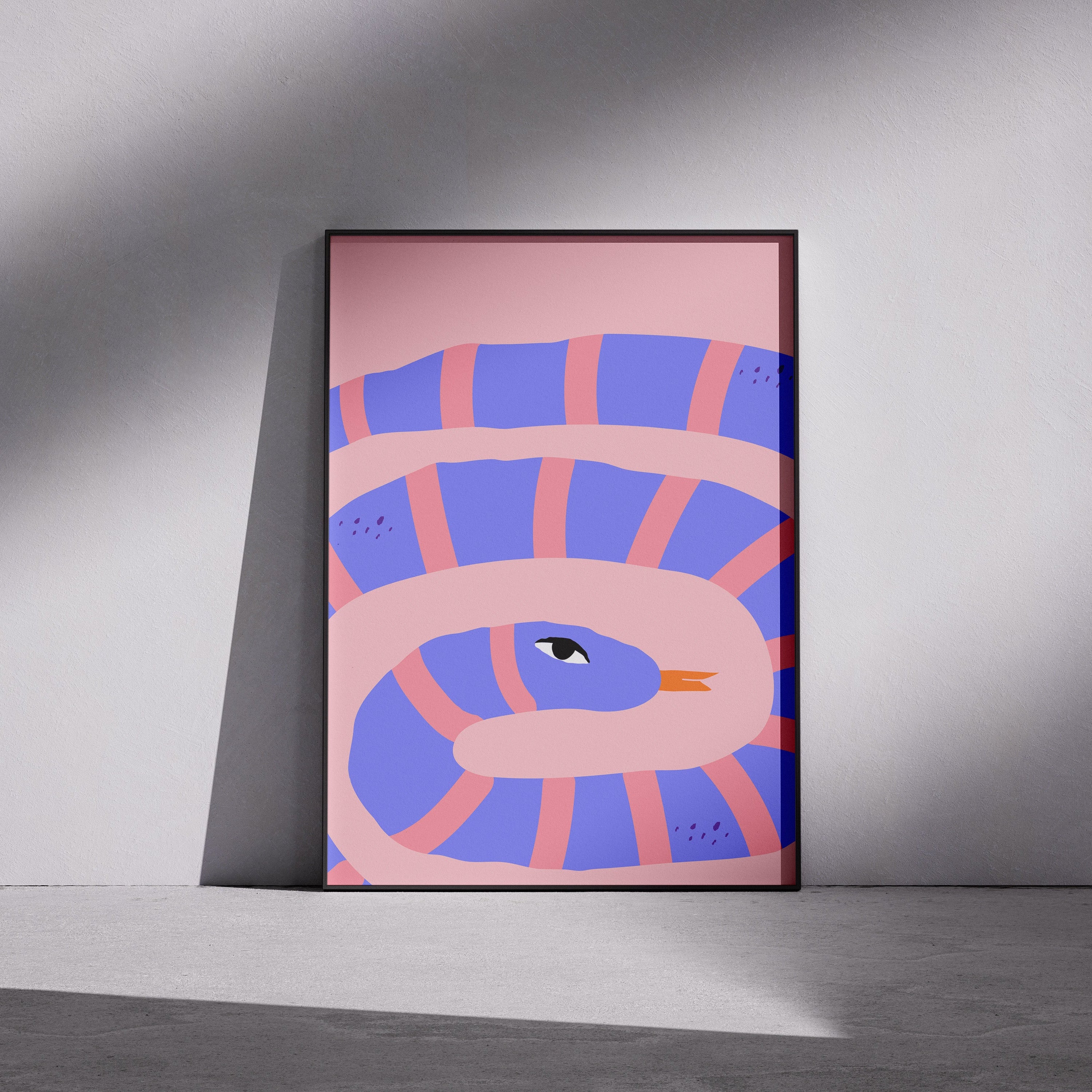 Framed abstract artwork with a snake design on a pink background, leaning against a gray wall.